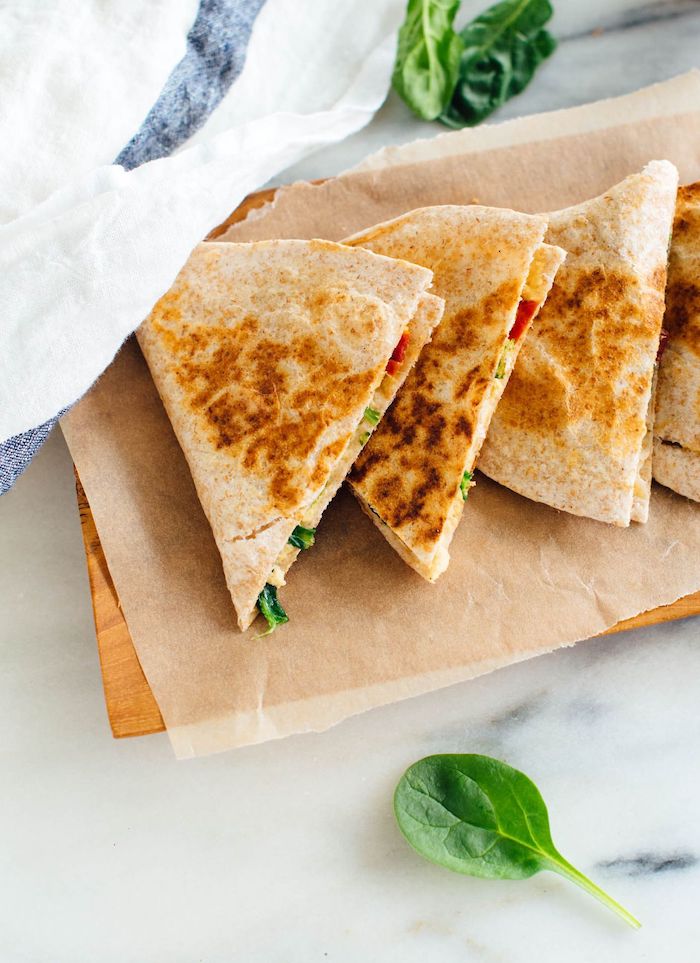 quesadillas with hummus and spinach cut up arranged on peper lined wooden tray vegan hors d oeuvres