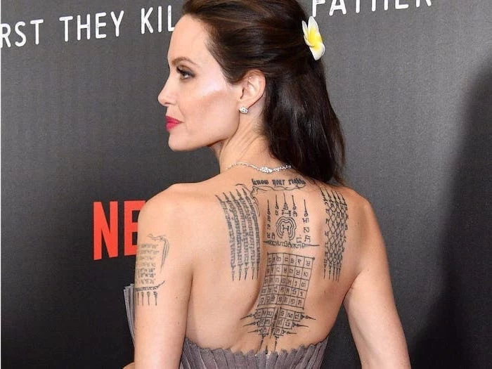 red carpet event spiritual tattoos angelina jolie back tattoos different symbols and sayings black background