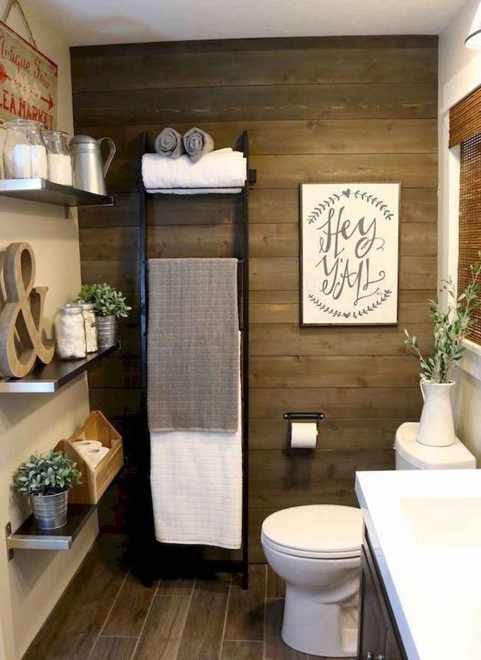 shiplap on the wall black ladder with towels farmhouse bathroom decor shelves with different accessories on them metal sign hanging on the walls