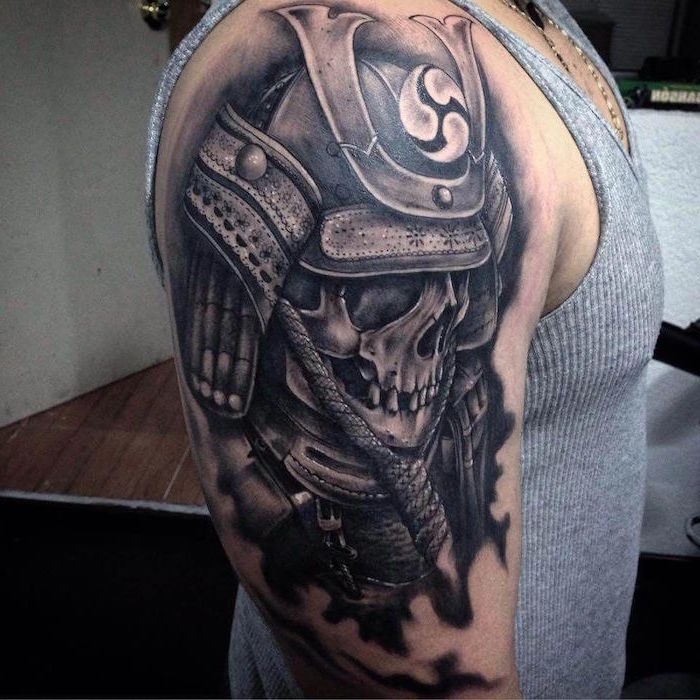 skull with armor shoulder tattoo made with black ink on man wearing gray tank top tattoo ideas for men