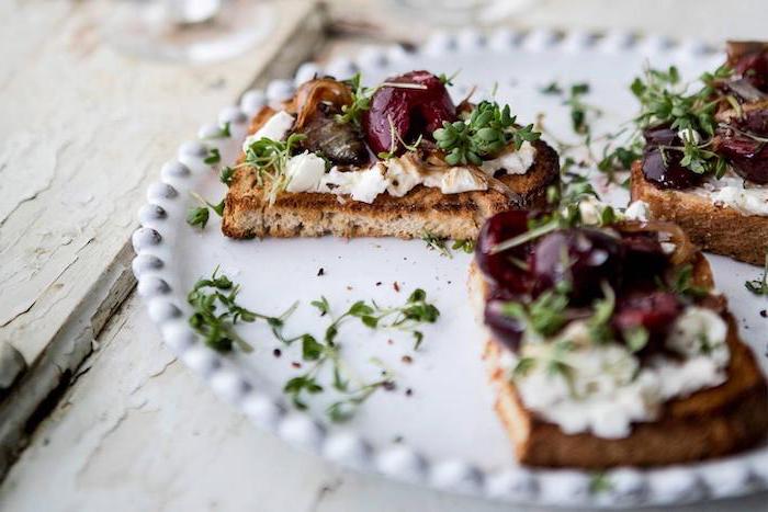 toast with cream cheese and olives garnished with sprouts vegan appetizer recipes arranged in white plate