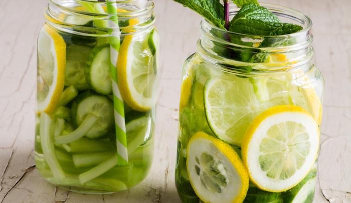 two glasses filled with celery cucumber lemon and lime what is detox garnished with fresh mint leaves