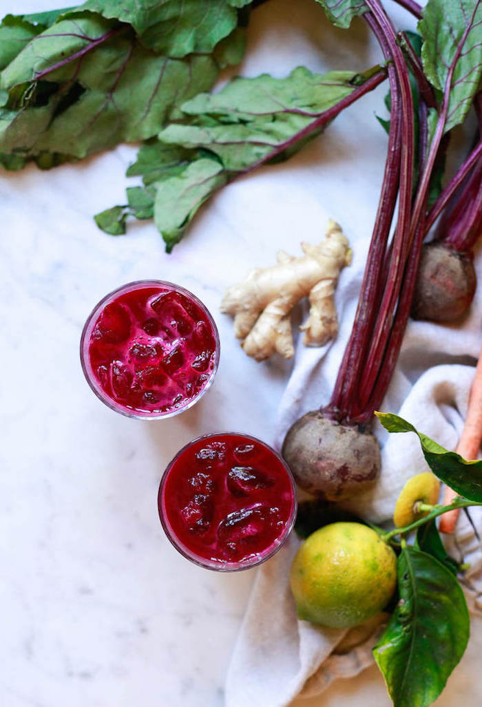 two glasses on marble surface filled with beet juice detox drinks for weight loss beetroot on the side lemon ginger