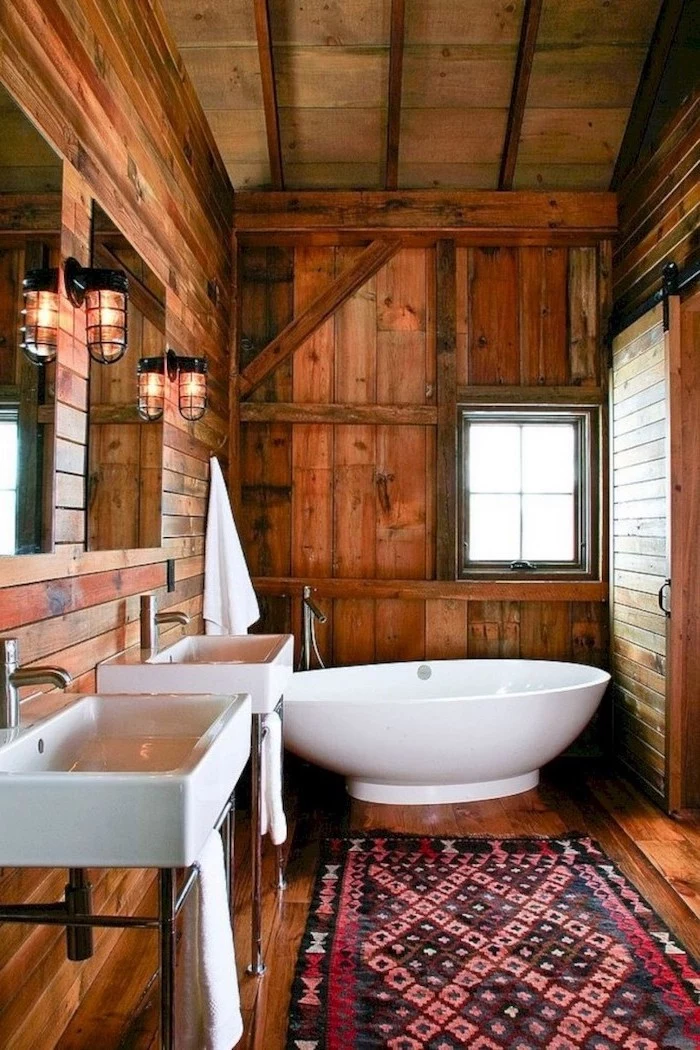 two sinks with mirrors and lamps hanging above them modern farmhouse bathroom wooden floor ceiling and walls with barn door modern farmhouse bathroom small rug on the floor