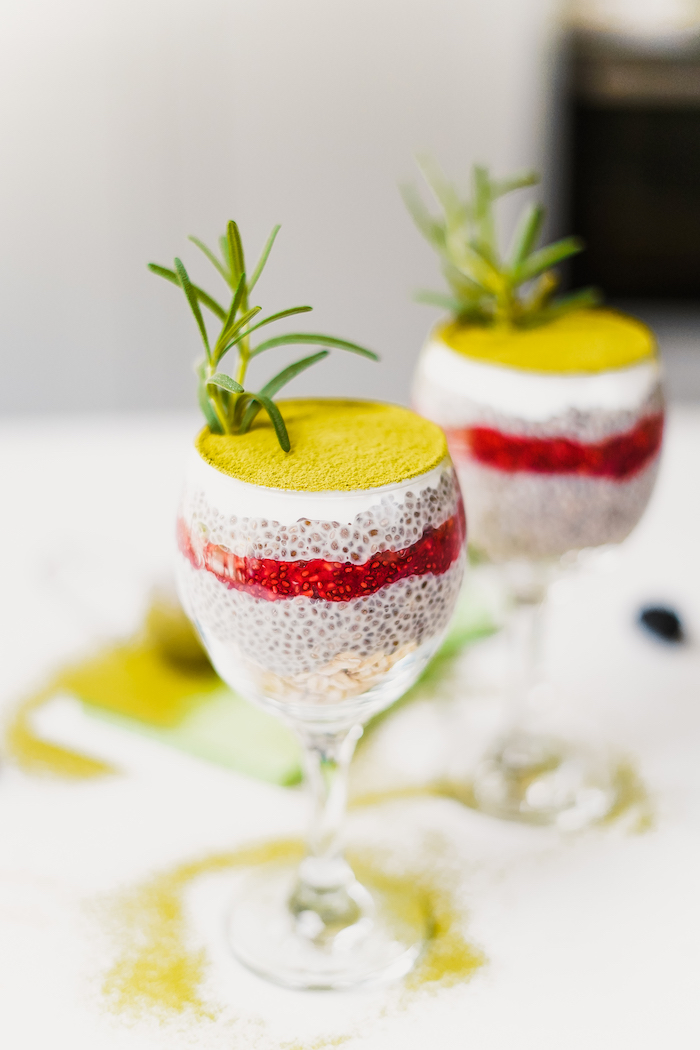 two wine glasses filled with chia pudding covered with matcha powder easy vegan appetizers garnished with fresh rosemary