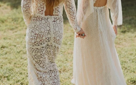 two women with long hair wearing all lace white long dresses holding hands boho beach wedding dress