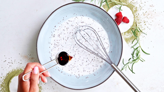 vegan bites milk with chia seeds honey added to it stirred together in ceramic bowl placed on white surface