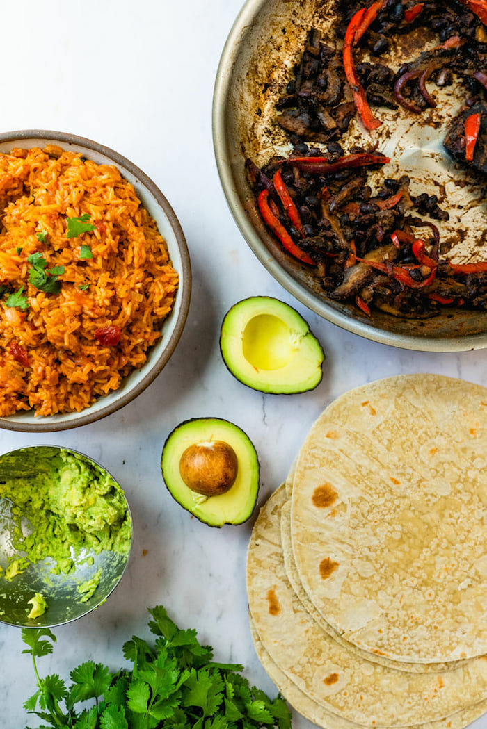 vegan burrito ingredients arranged on marble surface popular mexican food guacamole avocado rice tortillas