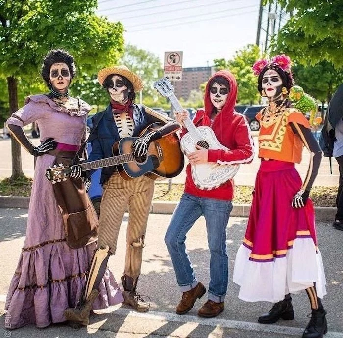 white and brown guitars held by two men two women next to them group halloween costume ideas four people dressed as characters from coco