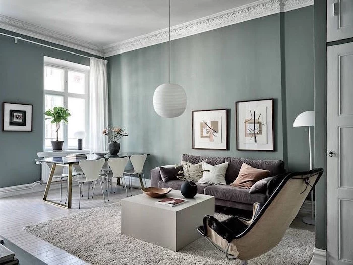 white coffee table gray sofa black leather armchair scandinavian interior design dark green walls dining table with white chairs