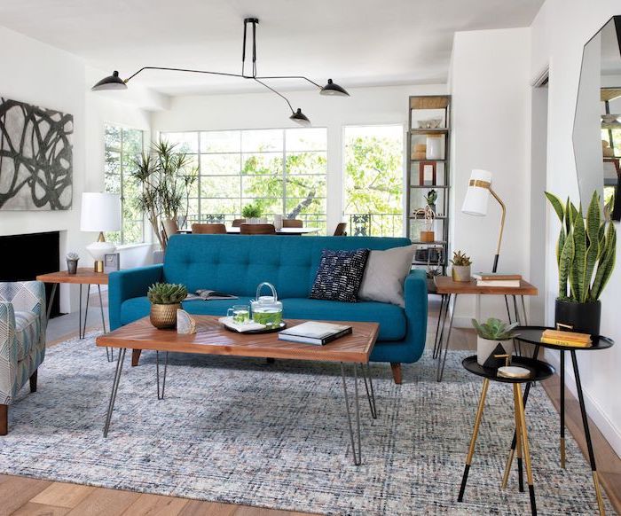 white walls mid century modern living room blue sofa with wooden coffee table and side tables blue and white carpet on wooden floor