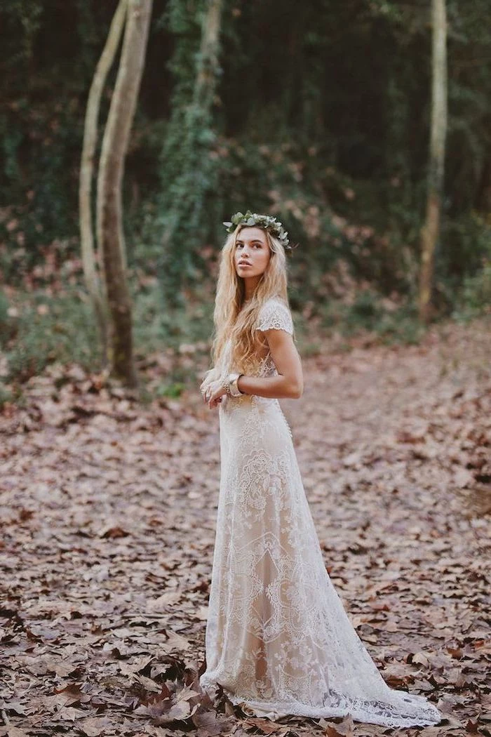 woman with long blonde wavy hair wearing all lace white bohemian wedding dress floral crown on her head