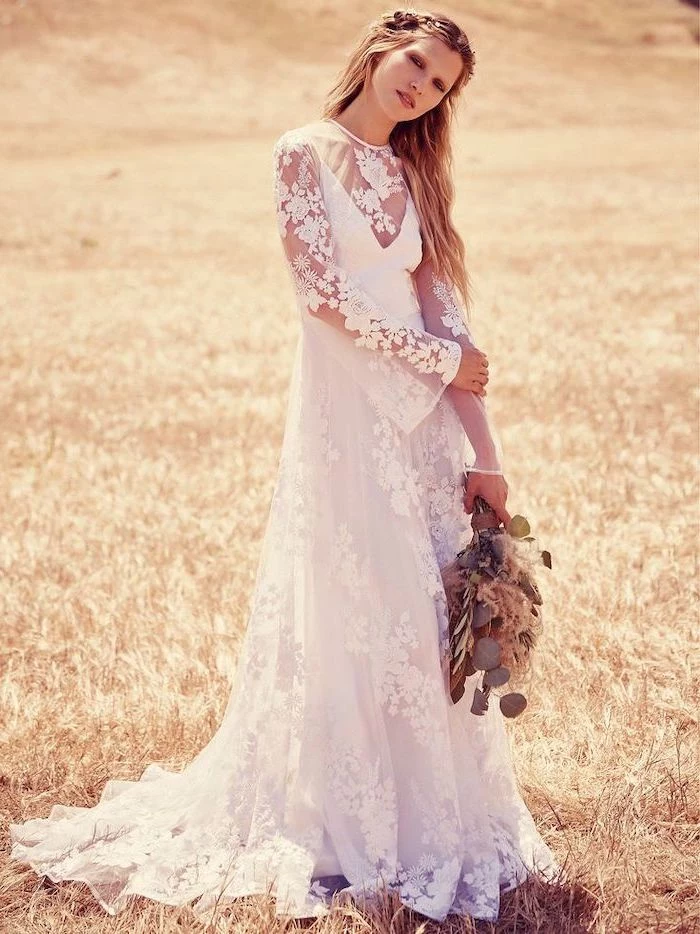 woman with long wavy blonde hair flowy wedding dress wearing dress made of tulle and lace with long sleeves