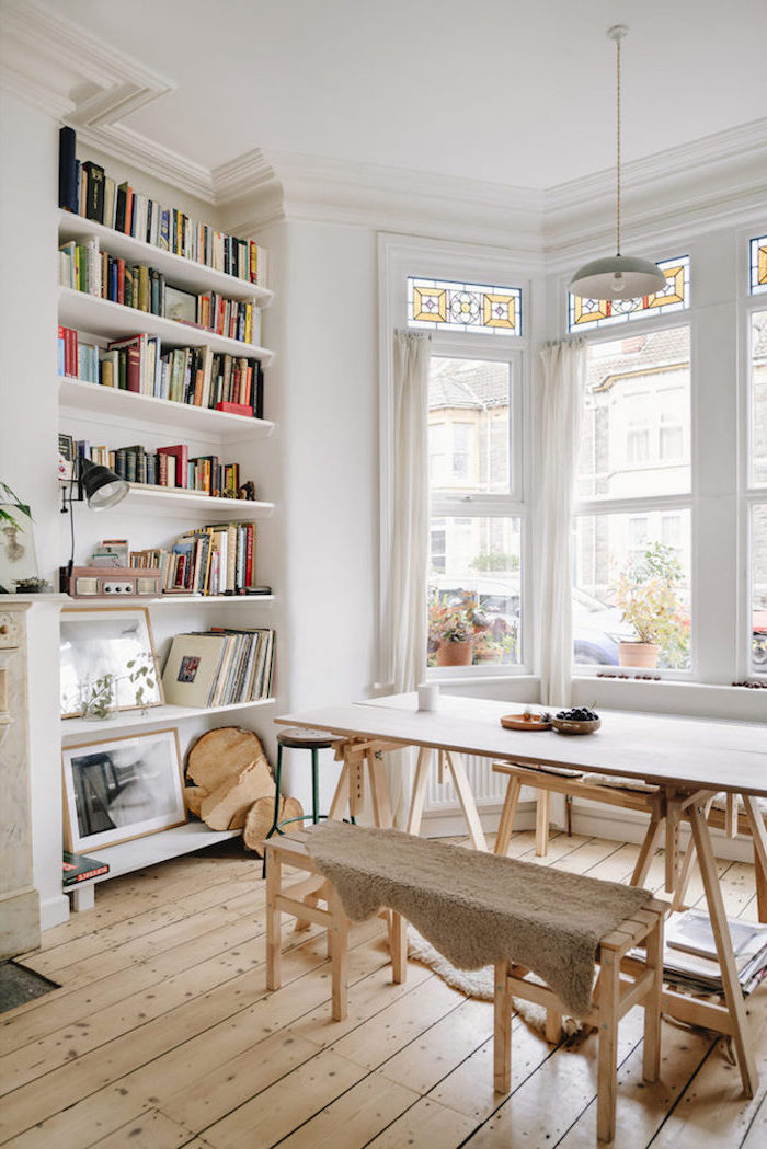 wooden dining table with wooden benches scandinavian design living room bookshelf in the wall white walls and wooden floor