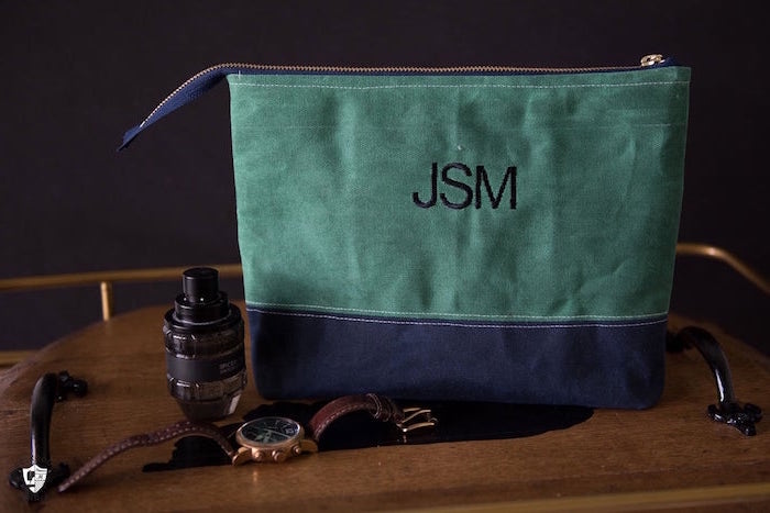 accessories bag made from blue and green velvet fabric good gifts for dad personalised with initials placed on wooden surface