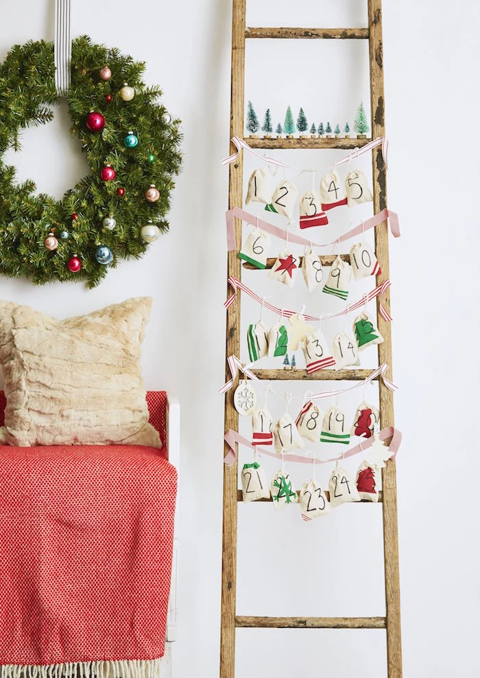advent calendar ideas wooden ladder red and white ribbons tied from one end to the other small bags hanging from them