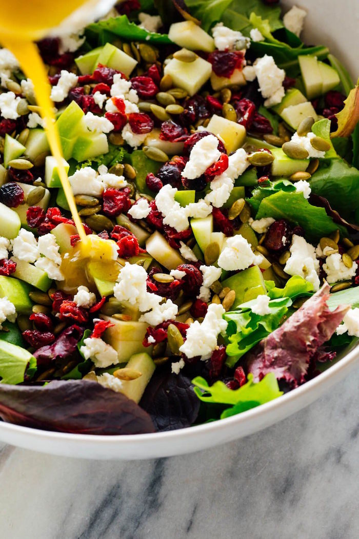 apple salad with kale pine nuts dried cranberries christmas food ideas white bowl placed on marble surface