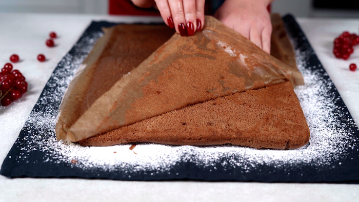 baked cake batter placed on towel covered with powdered sugar christmas party food ideas buffet baking paper removed