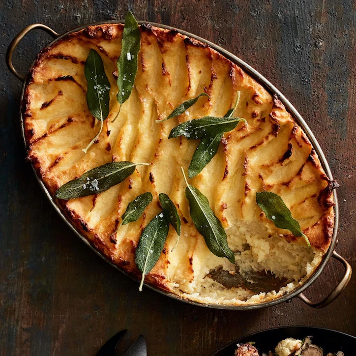 baked potato mash with fried sage leaves thanksgiving side dishes 2020 casserole placed on wooden surface