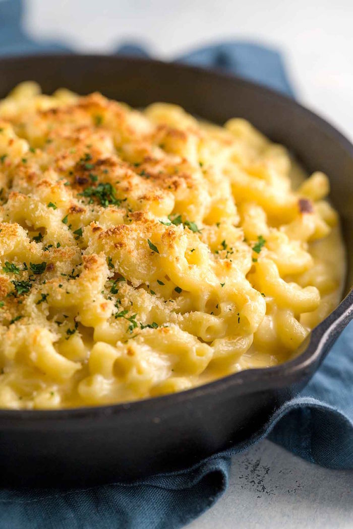 black skillet filled with baked mac and cheese easy christmas dinner menu with panko crumbs garnished with chopped parsley