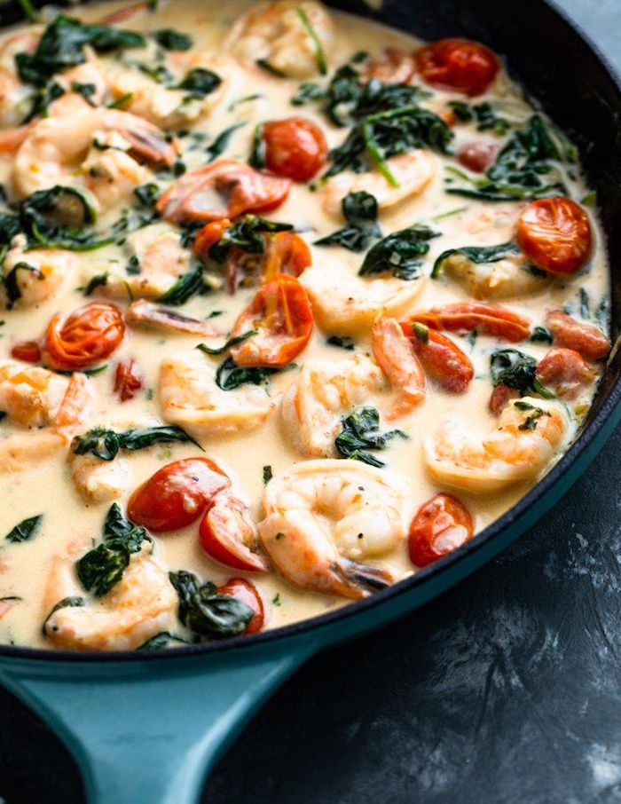 black skillet with creamy tuscan shrimp with spinach and cherry tomatoes baked shrimp recipes
