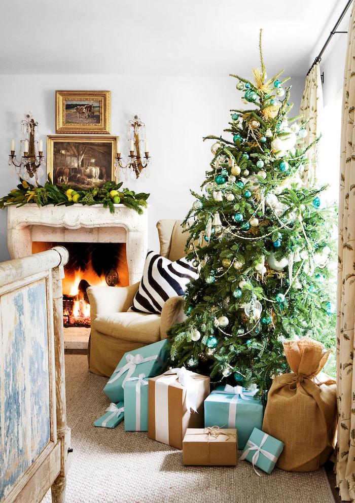 blue gold baubles and ornaments on real christmas tree decorations ideas 2020 blue and gold wrapped presents underneath next to fireplace