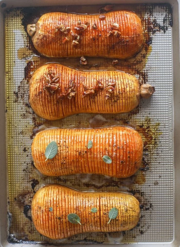 butternut squash with slits covered with walnuts cinnamon placedon baking sheet thanksgiving food ideas roasted