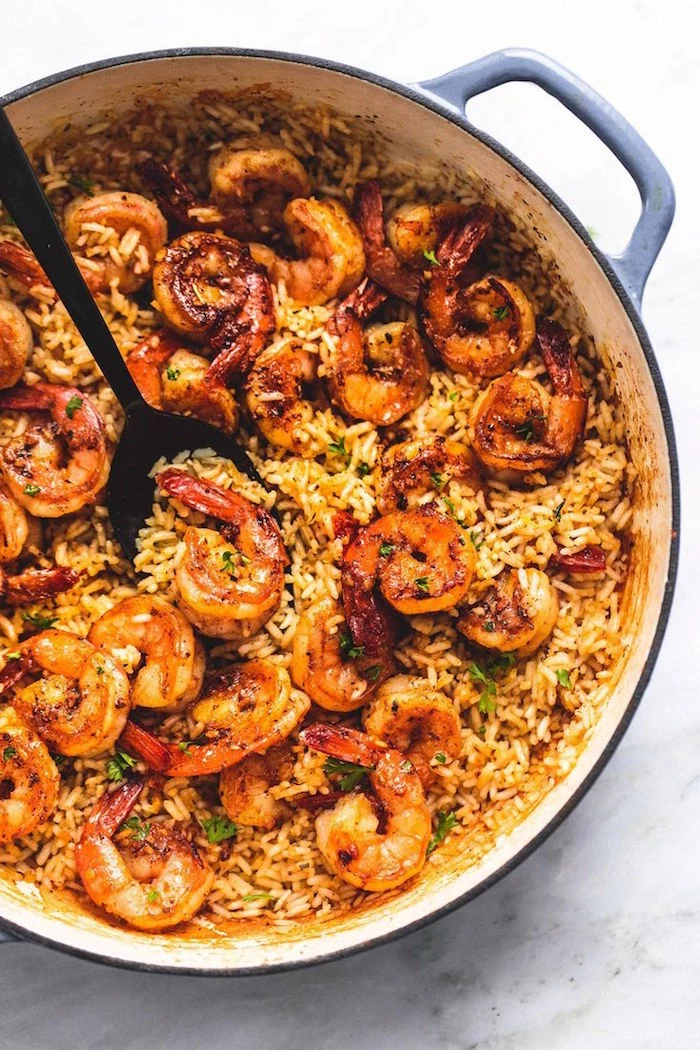 cajun shrimp and rice baked in large skilled stirred with black spoon shrimp dinner ideas placed on marble surface