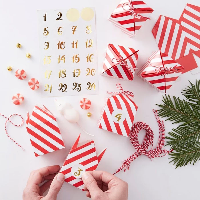 calendar made with red and white take out boxes with golden numbers on them placed on white surface diy advent calendar