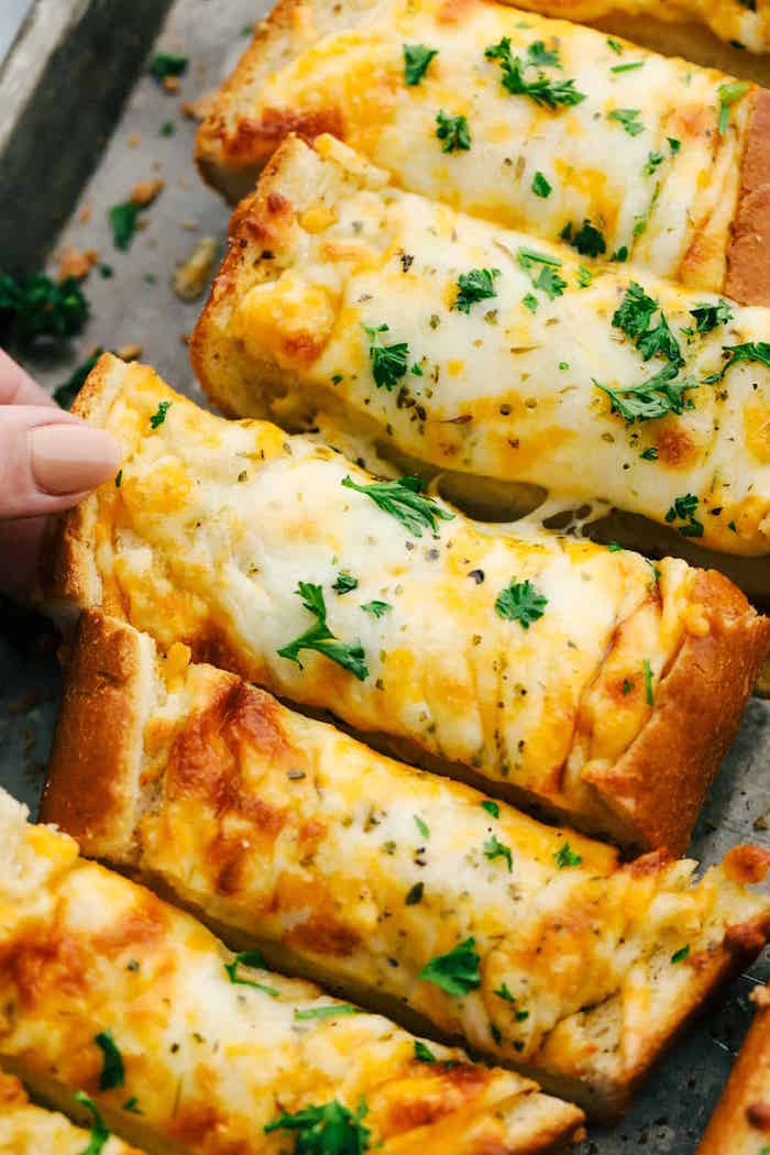 cheesy garlic bread bites baked in baking sheet easy christmas dinner menu garnished with chopped parsley
