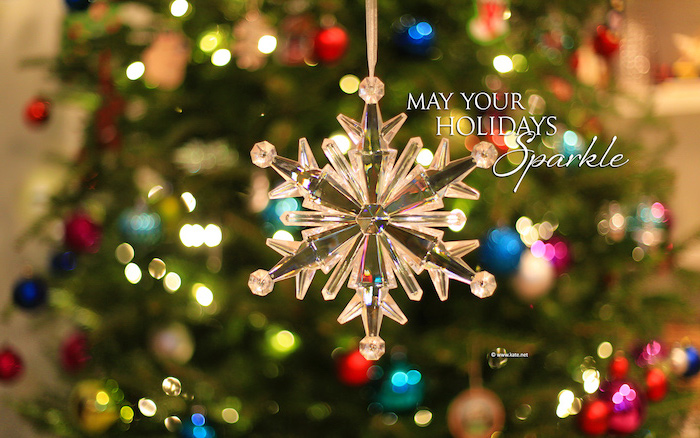 christmas background iphone may your holidays sparkle written next to glass snowflake ornament lights in the background