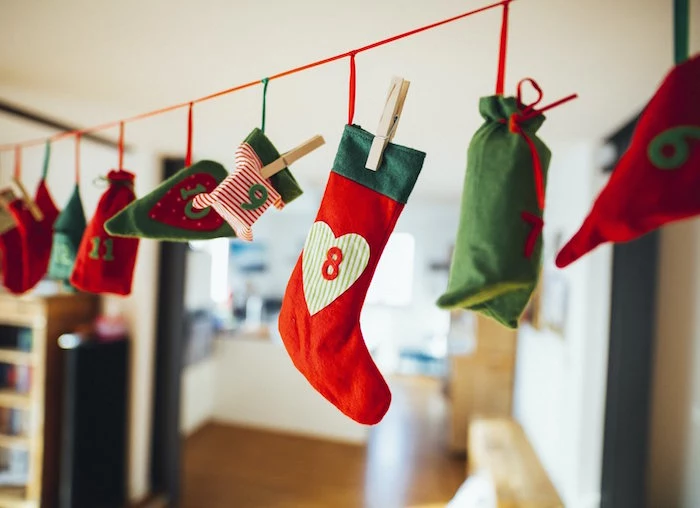 christmas countdown calendar small stockings and bags in red and green hanging from a red string with numbers on them