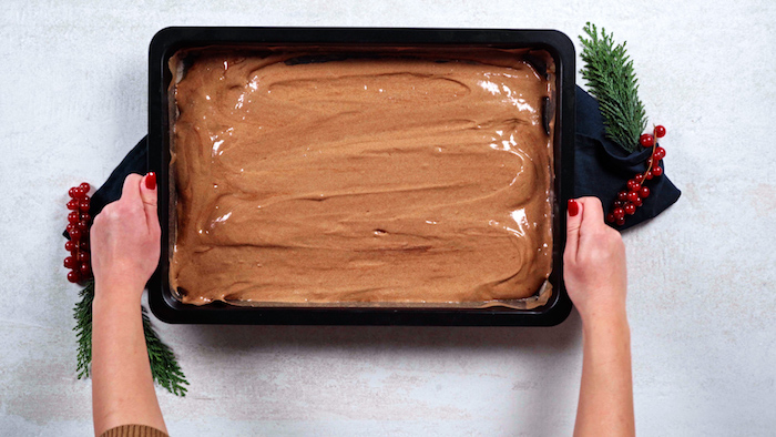 christmas party food ideas buffet cake batter being spread out evenly onto baking sheet cranberries on the side