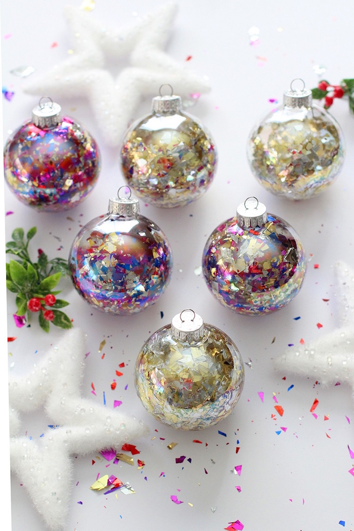 christmas tree decorations 2020 six ornaments filled with glitter and confetti step by step diy tutorial placed on white surface with white star shaped ornaments