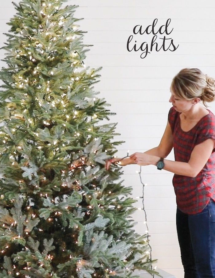 christmas tree theme ideas how to decorate a tree step by step woman hanging lights on the tree