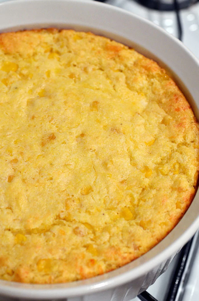 close up photo of corn casserole baked in white round casserole dish easy thanksgiving side dishes
