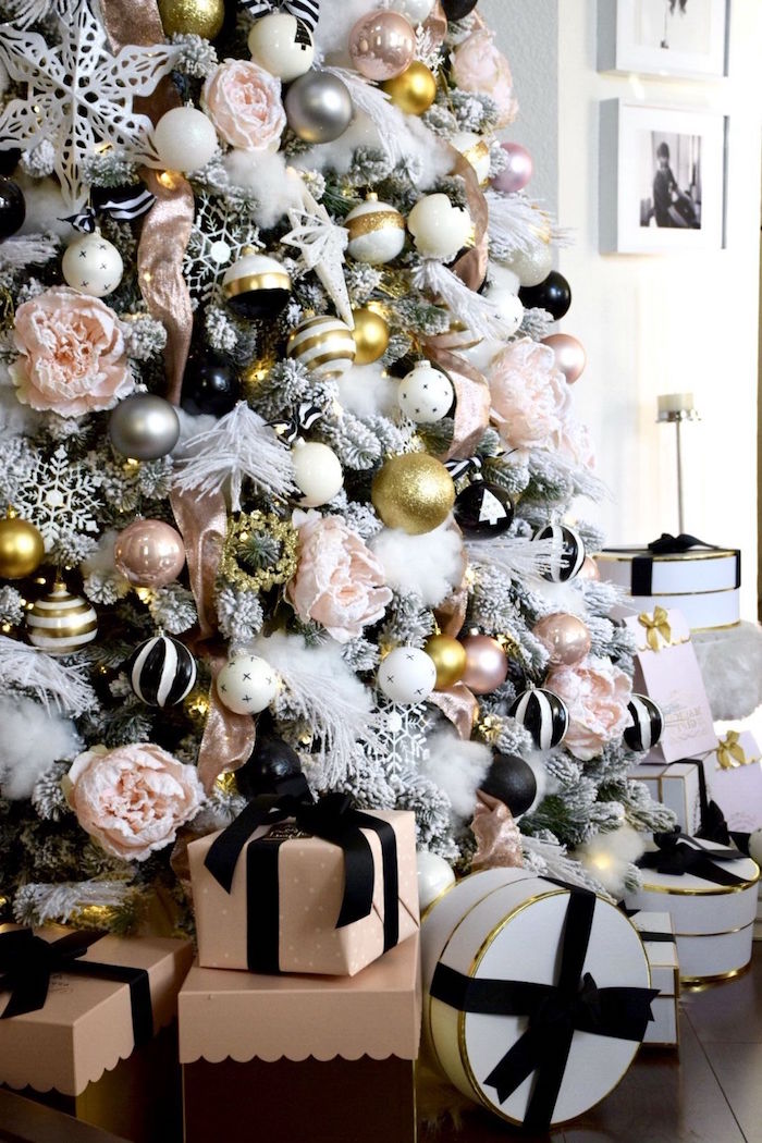 close up photo of faux white tree covered with white cotton feathers stars baubles in black and white gold and silver christmas tree decorations ideas 2020 presents underneath