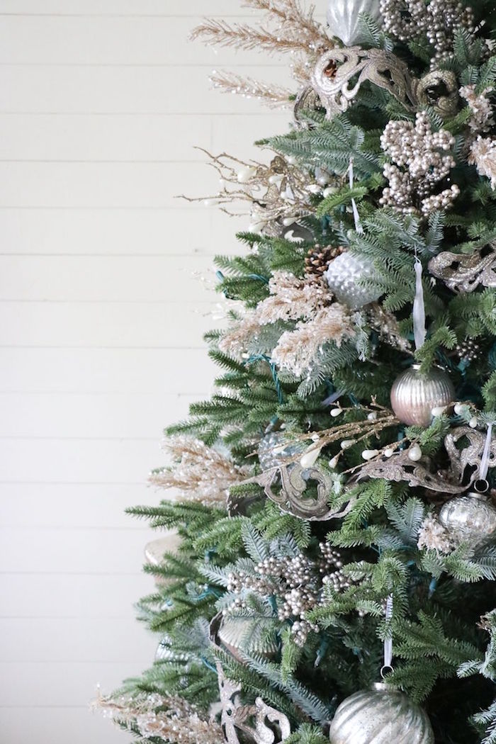 close up photo of tree decorated with silver baubles and ornaments christmas tree theme ideas gold faux branches and flowers pinecones