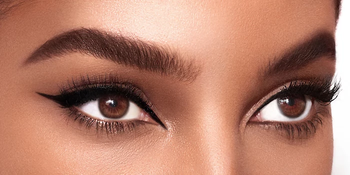 close up photo of woman with brown eyes light brown eyebrows cat eye makeup with black eyeliner