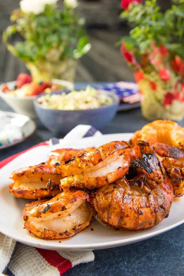 colossal grilled shrimp with harissa marinade placed on white plate shrimp recipes placed on dark granite table