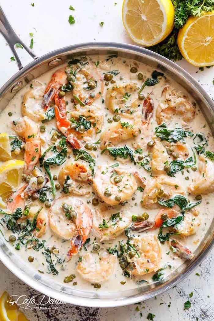 creamy garlic butter shrimp piccata shrimp recipes with spinach garnished with capers lemon wedges