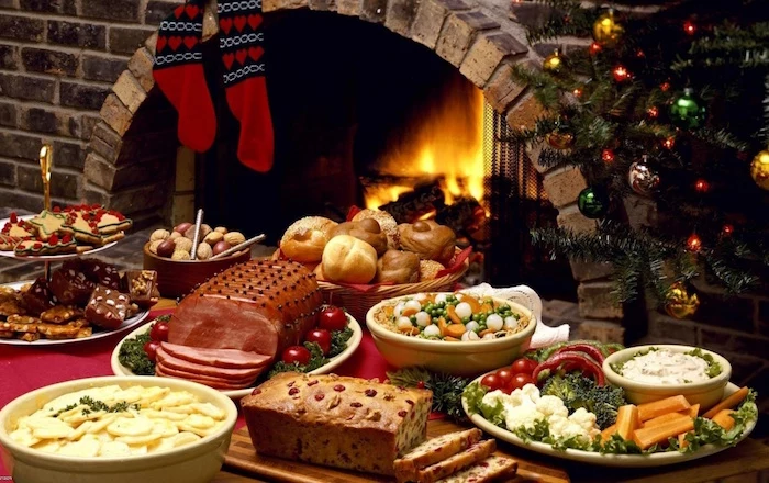 fireplace next to christmas tree christmas eve dinner ideas table with red table cloth lots of different dishes on the table