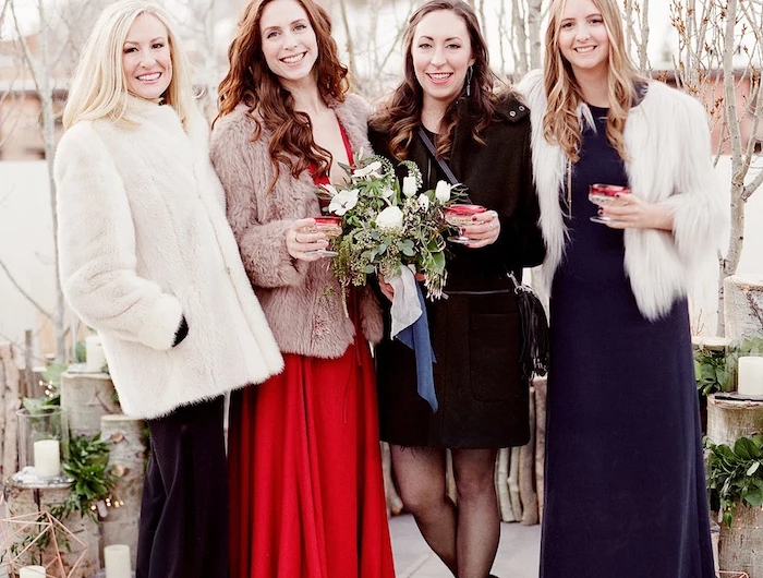 four women wearing coats black purple and red dresses affordable wedding guest dresses holding glasses