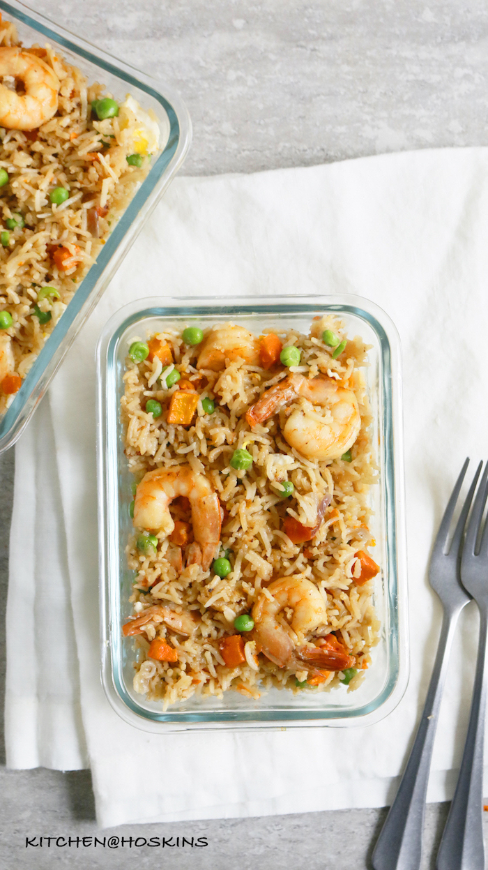 garlic shrimp recipe two glass bowls filed with fried rice with vegetables and shrimp two forks on the side placed on white table cloth