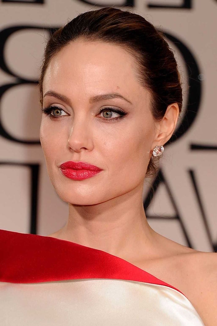 golden globe awards red carpet cat eye makeup angelina jolie wearing white and red dress with diamond earrings hair in low updo
