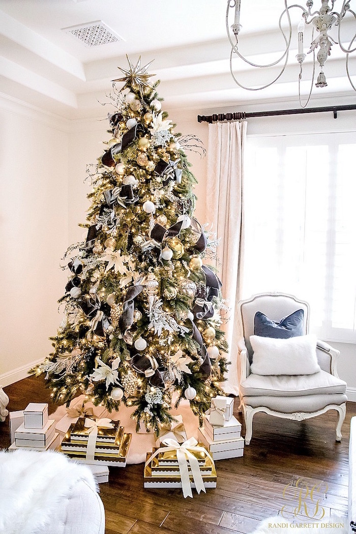 gray gold white baubles and ornaments black ribbon christmas tree ideas 2020 presents underneath placed next to white armchair