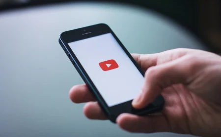 hand holding phone opening youtube on the phone youtube channels icon on white background