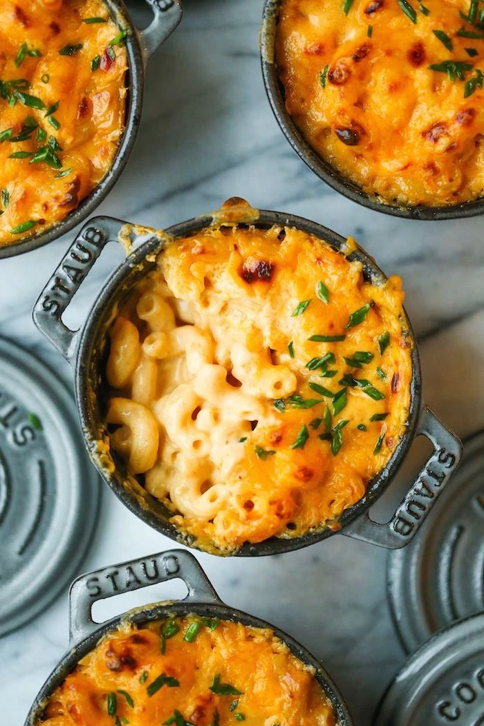 mac and cheese baked in small ceramic casserole thanksgiving vegetable side dishes arranged on marble surface