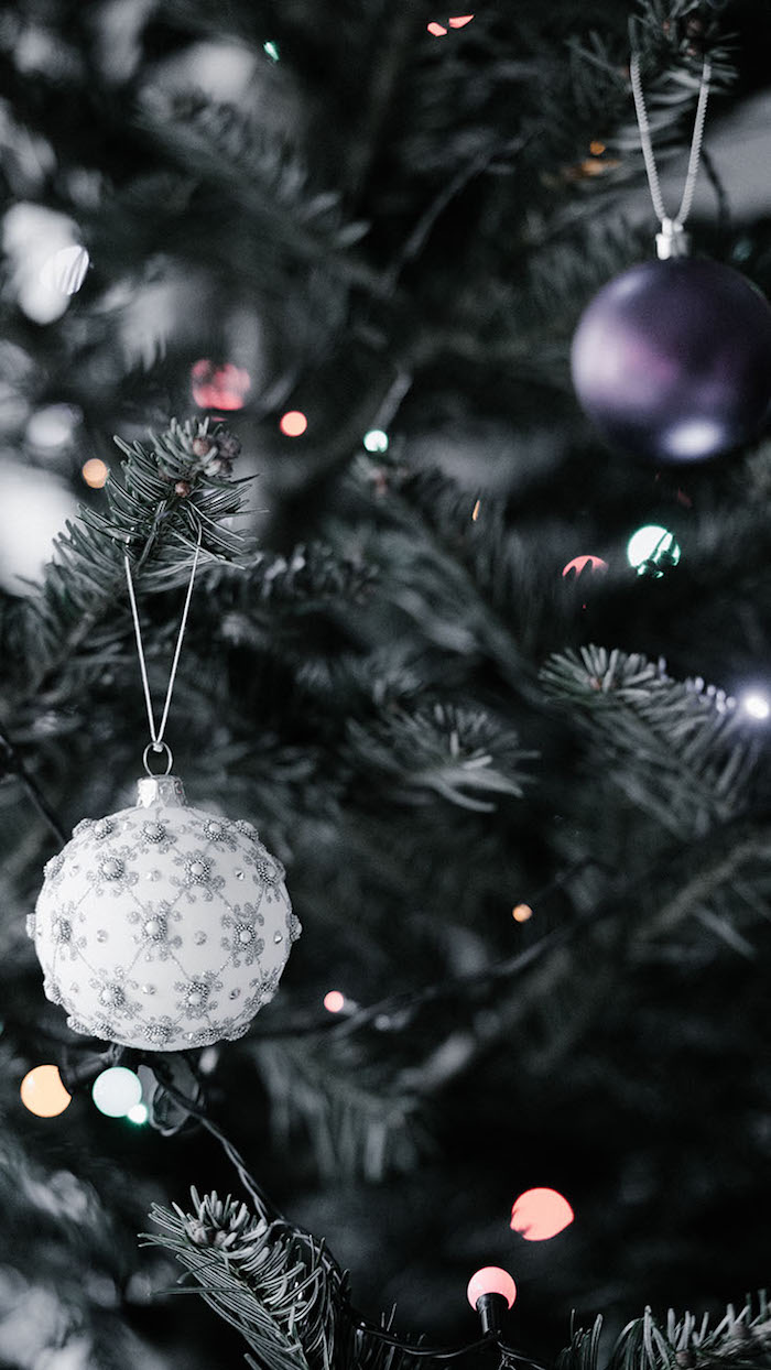 merry christmas wallpaper close up photo of christmas tree decorated with fairy lights purple white and silver baubles