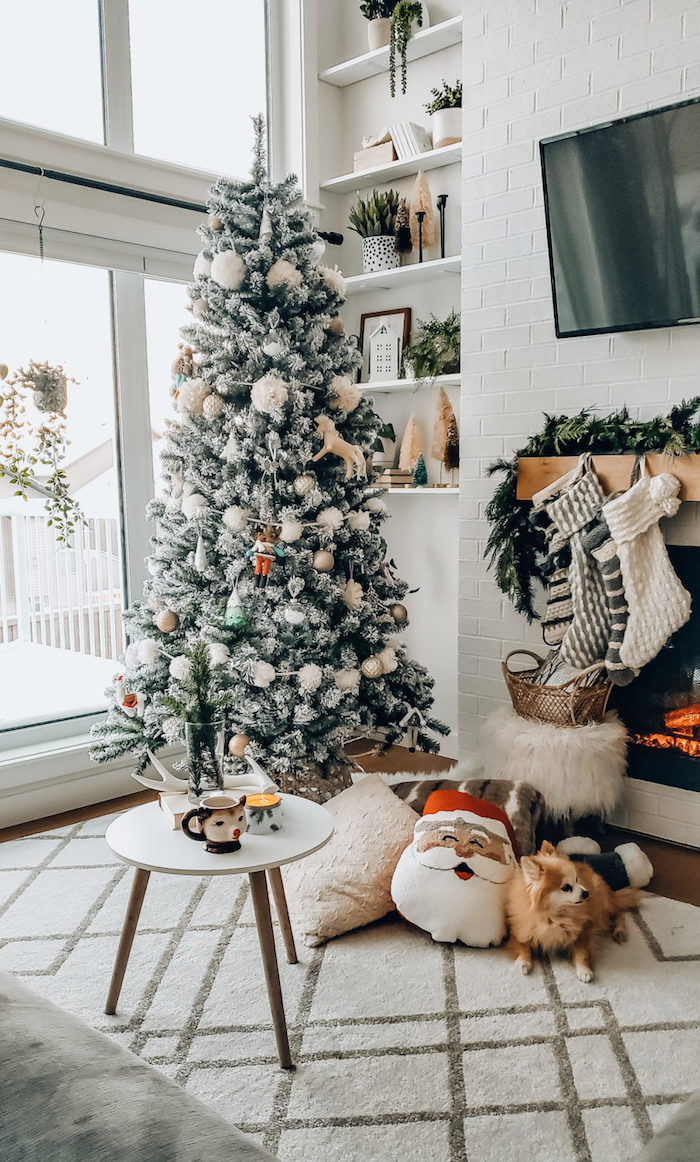 minimalist christmas tree decorations ideas 2020 standing next to fireplace with stockings in pink and gray on white carpet